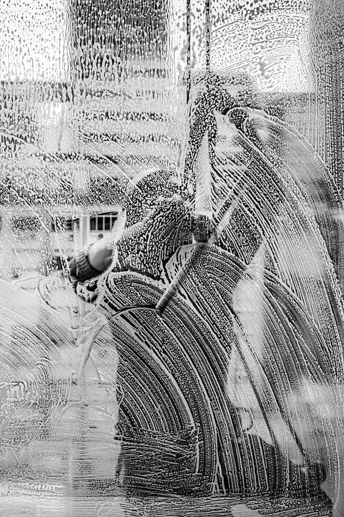 Monochromatic image capturing workers cleaning a window in Buenos Aires.